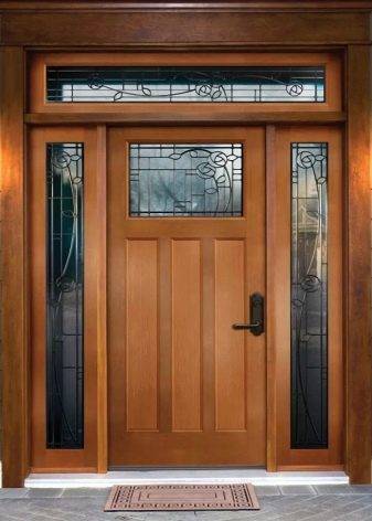 Кованые двери с накладкой под старину красивые входные со стеклом и навесом, металлические элементы в декоре деревянного полотна с козырьком из железа в дом и квартиру