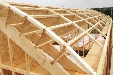 Обзор характеристик и применение двутавровых деревянных балок в строительстве домов